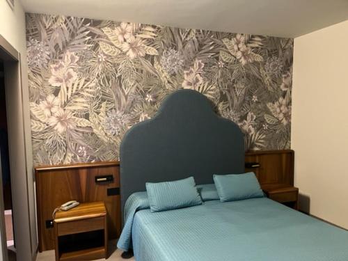 a bedroom with a bed and a wall with flowers at Continental Hotel in Lovere