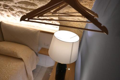a lamp in a room next to a bed at Pietrabianca Santa Maria Apartments in Manfredonia