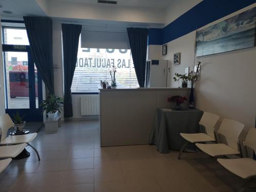 een wachtkamer met een aanrecht met stoelen en een tafel bij Hostel de las Facultades in Santander