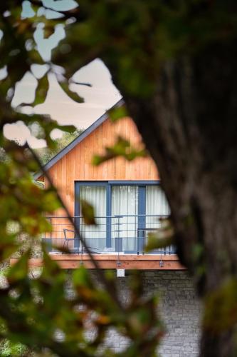 a house seen through the branches of a tree at Les pavillons de La Libellule in Beauraing