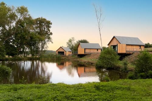 a group of cottages next to a river at Les pavillons de La Libellule in Beauraing