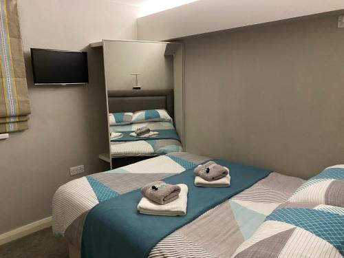 a room with two beds with towels on them at Ocean Hideaway @ Portmore Bay in Portstewart