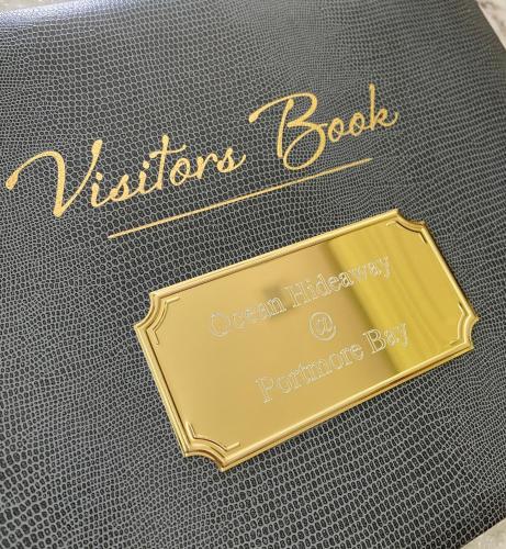 a book with a gold plate on the side of it at Ocean Hideaway @ Portmore Bay in Portstewart