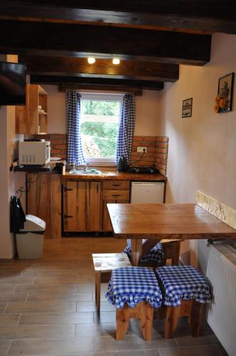 a kitchen with a wooden table and a window at András penzión in Krásnohorské Podhradie