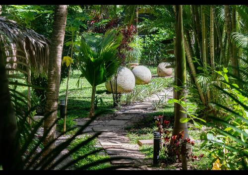 a stone path in a garden with palm trees at Villas Pura Vibra in Potrero