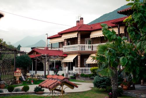 una casa grande con un banco delante en Ξενώνας Χάραμα, en Kato Loutraki