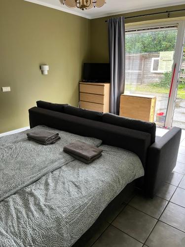 a bedroom with a bed with two brown pillows on it at Logies Waasland in Sint-Niklaas