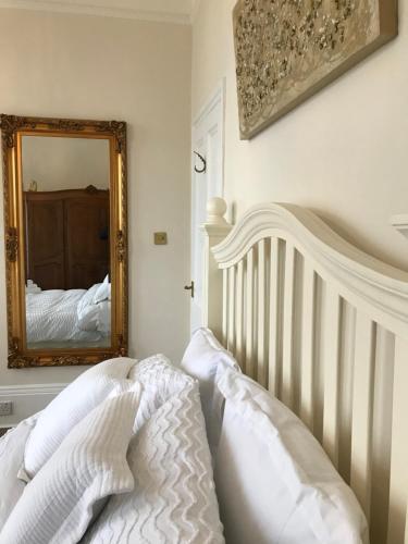 a bedroom with a white bed and a mirror at The Leas View in Folkestone