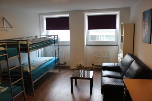 薩爾布呂肯的住宿－FULL FLAT 3 BEDROOMS SAARBRUCKEN CENTER -11 PEOPLE，客厅配有双层床和沙发。
