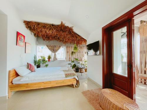 ein Schlafzimmer mit einem Bett in einem Zimmer in der Unterkunft Hotel Làng Kò Hơ in Da Lat