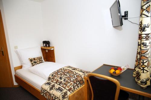 a bedroom with a bed and a desk with a television at Haus Mühlenbrock in Schermbeck