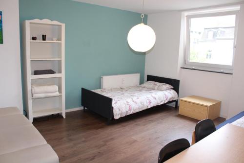 a small bedroom with a bed and a window at ROOMS in SHARED HOUSE SAARBRUCKEN Center in Saarbrücken