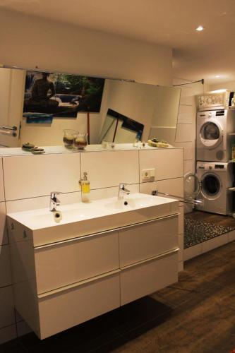 a bathroom with two sinks and a washing machine at ROOMS in SHARED HOUSE SAARBRUCKEN Center in Saarbrücken
