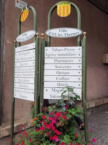 a sign with some flowers in front of a building at Ax, Superbe appartement 2 ch jusqu'à 5 pers in Ax-les-Thermes
