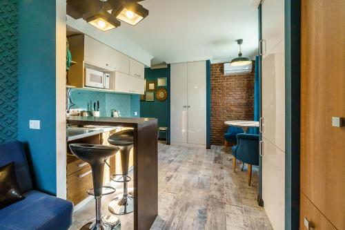a kitchen with blue walls and a bar with stools at LUXE on Tereshkovoy 8 in Novosibirsk