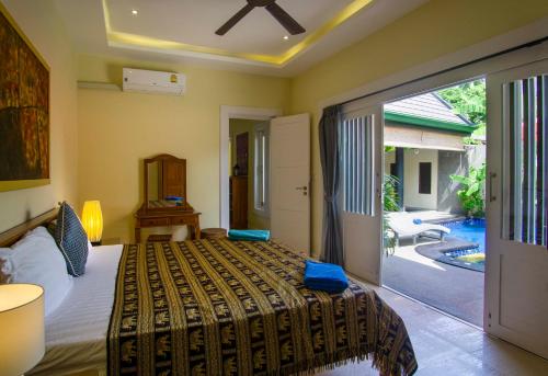 1 dormitorio con 1 cama y puerta corredera de cristal en Villa Topaz, en Laem Set Beach