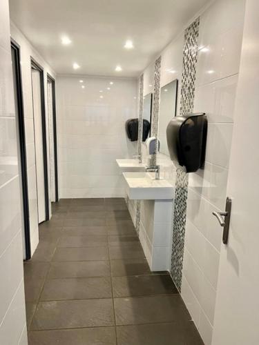 une salle de bain avec deux lavabos et deux miroirs dans l'établissement Kyriad Direct Reims Bezannes, à Reims