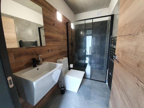 La salle de bains est pourvue d'un lavabo blanc et d'une douche. dans l'établissement Relax Vila Lipno 2 u pláže Windy Point, à Černá v Pošumaví