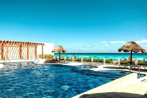a swimming pool with a view of the ocean at HotelZone L17 Beach Access in Cancún