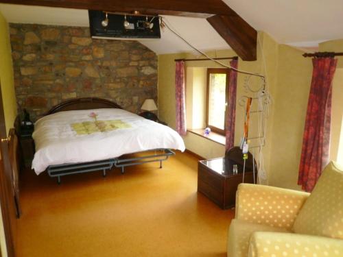 une chambre avec un lit et un mur en pierre dans l'établissement Charming House in Theux with Private Pool, à Theux
