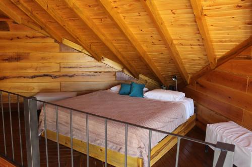 a bedroom in a log cabin with a bed at Ayres del Champaqui Hotel Boutique Experiencial & Spa in Villa General Belgrano