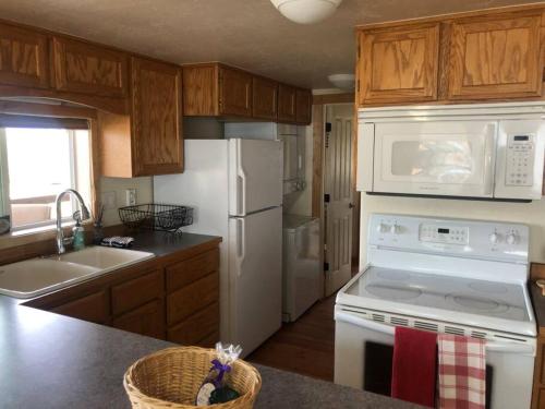 a kitchen with white appliances and wooden cabinets at Stunning Views, Prime Location in Hamilton