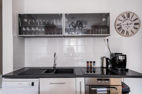 a kitchen with a sink and a clock on the wall at Jacuzzi and privacy with 2 balconies and FREE garage in Budapest