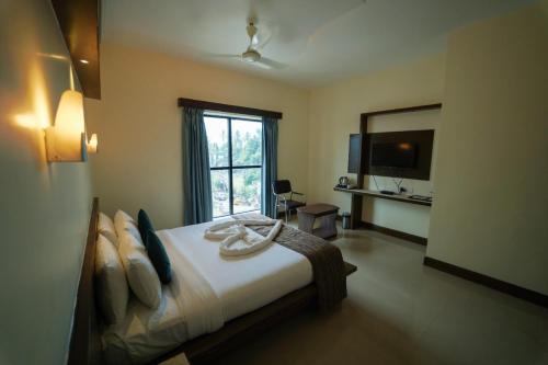 a bedroom with a bed and a large window at Vari Park - Comfort Stay in Dindigul