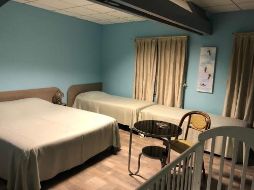 a room with two beds and a table and a crib at Hôtel De La Mare -restaurant pour les clients sur réservation in Avrigny