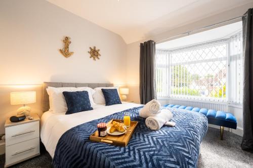 een slaapkamer met een bed met een dienblad met eten erop bij Mulberry House - Luxurious and Modern 4-Bed in Solihull near NEC,JLR, Airport, Resorts World, HS2 in Solihull