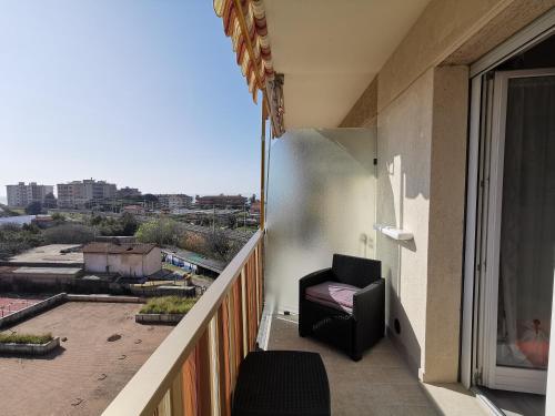 a balcony with a chair and a view of a city at Appartamento - IRIS - Vallecrosia in Vallecrosia