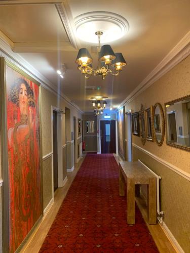a hallway with a painting on the wall and a table at Beech Mount Hotel - Free Parking in Liverpool