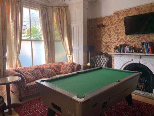 a living room with a couch and a pool table at Beech Mount Hotel - Free Parking in Liverpool