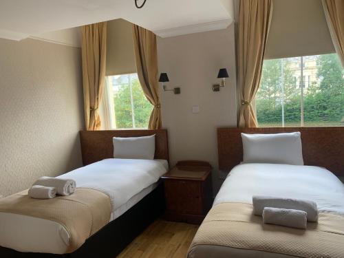 two beds in a room with two windows at Beech Mount Hotel - Free Parking in Liverpool