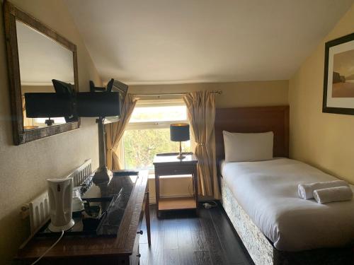 a bedroom with a bed and a desk and a window at Beech Mount Hotel - Free Parking in Liverpool