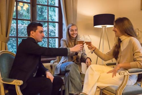 a group of people sitting around drinking wine at Château-ferme des Abys in Paliseul