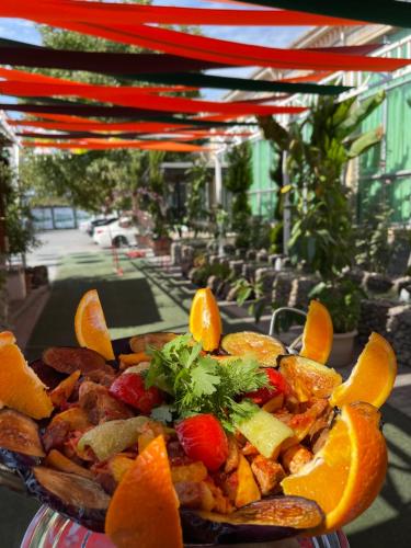 a plate of food on a table with orange slices at Qafqaz Fountain Villa in Gabala
