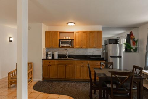 a kitchen with wooden cabinets and a table and a kitchen with a tableablish at Puu Koa Palms vacation rental in Haiku