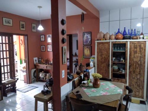 a kitchen with a table and a dining room at Casa aconchegante térrea à 3min de carro do centro e praia central in Garopaba