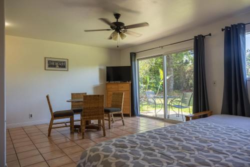 a bedroom with a bed and a table and chairs at Puu Koa Palms vacation rental in Haiku
