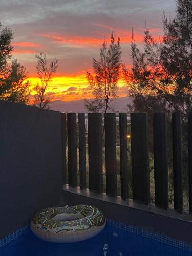 a view of a sunset through a fence at Casa Aire de Mar, modern house with private pool, overlooking Baviera golf, within walking distance of beach in Vélez-Málaga