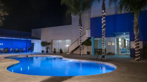 a swimming pool in front of a building at night at Staybridge Suites Guadalajara Expo by IHG in Guadalajara