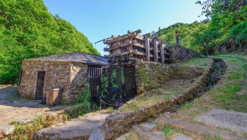 an old stone building on the side of a hill at Apartamento La Corrada in Santa Eulalia de Oscos