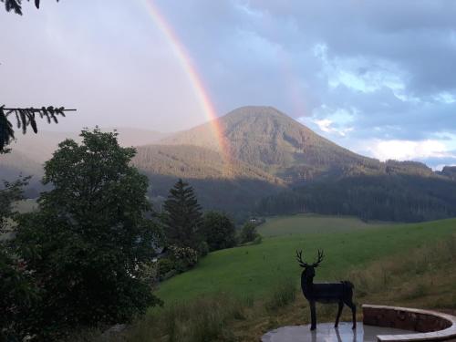 a statue of a deer with a rainbow in the background at Chalet Weiberle Hochschwab in Etmissl