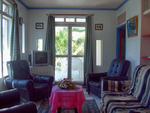 a living room with two chairs and a tv at Villa Acajou sur Mer in Rodrigues Island