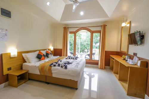 een slaapkamer met een groot bed en een raam bij Coral Beach Maldives in Hangnaameedhoo