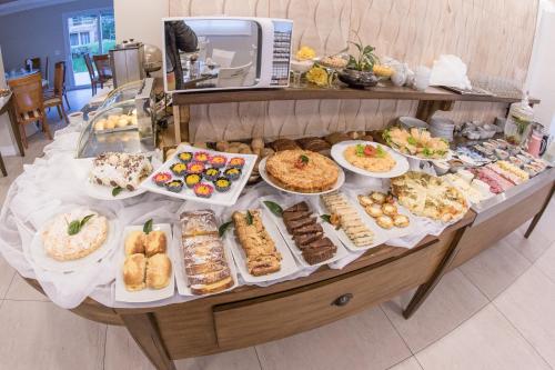 a buffet filled with different types of pastries and desserts at Hotel Gramado Interlaken in Gramado