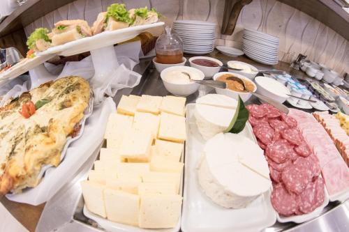 a table topped with cheese and meats and other foods at Hotel Gramado Interlaken in Gramado