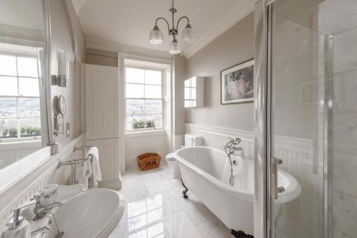ein Badezimmer mit zwei Waschbecken, einer Badewanne und einer Dusche in der Unterkunft Luxury Georgian Duplex in Central Bath in Bath