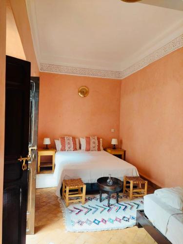 a bedroom with a large bed with orange walls at Riad Dialna in Marrakech